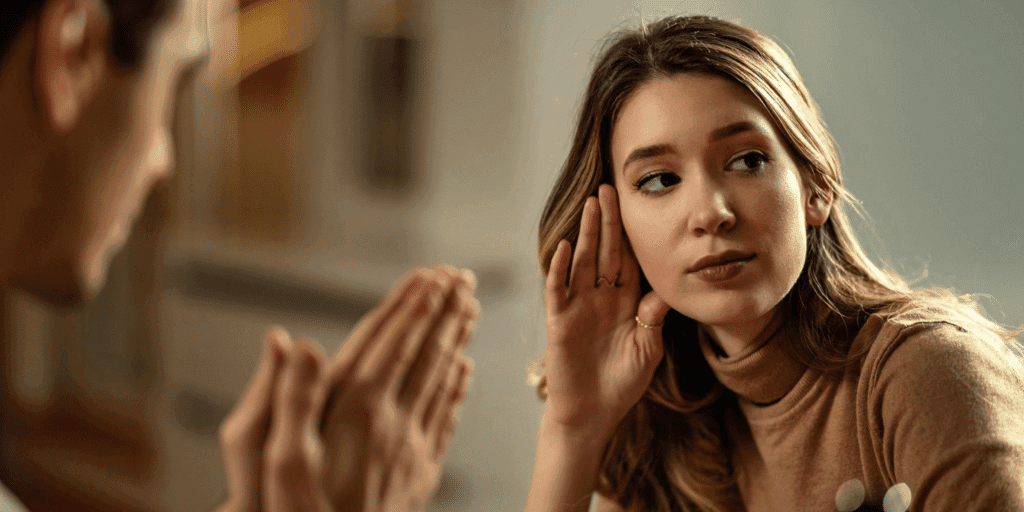 A woman looks away from a man, body language that shows she will not open up to him, a sign that she is not that interested in having a relationship with this person.