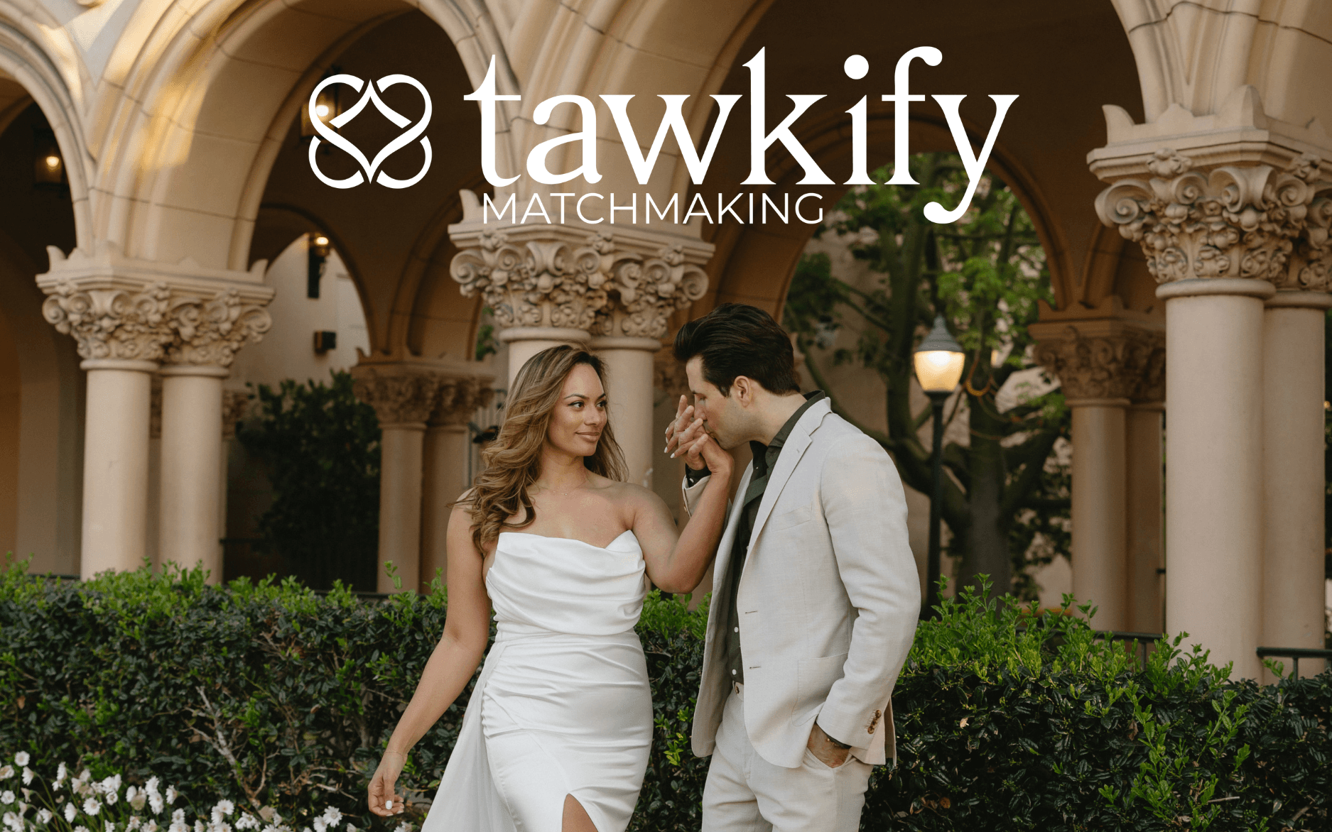 Tawkify matchmaking photo of a couple being photographed after their engagement with the man kissing the woman's hand as a romantic gesture.