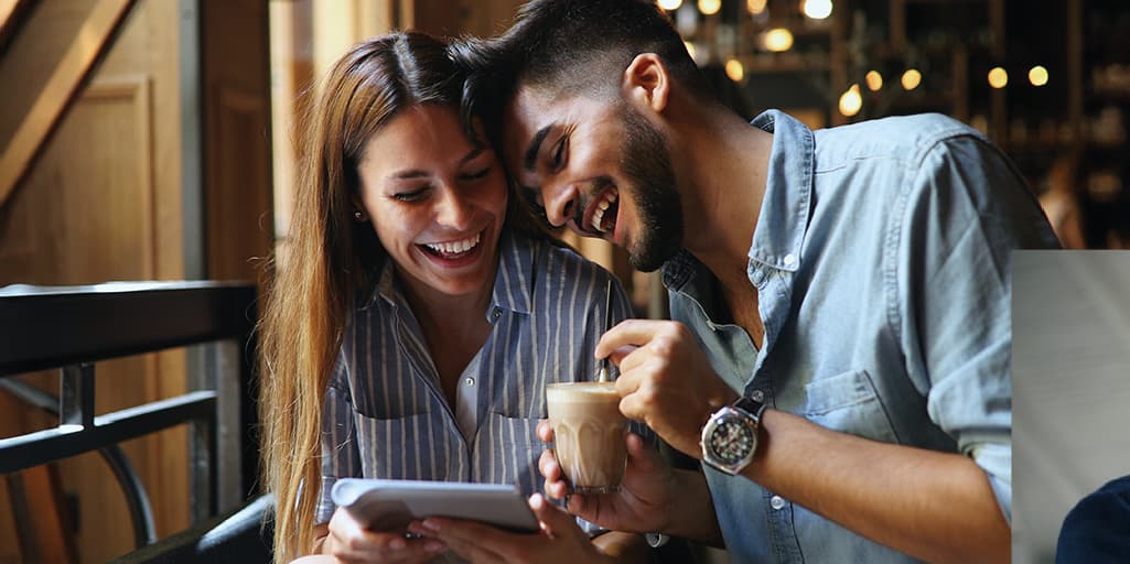 A young professional couple joke with each other and laugh together after meeting through a Tawkify matchmaker.