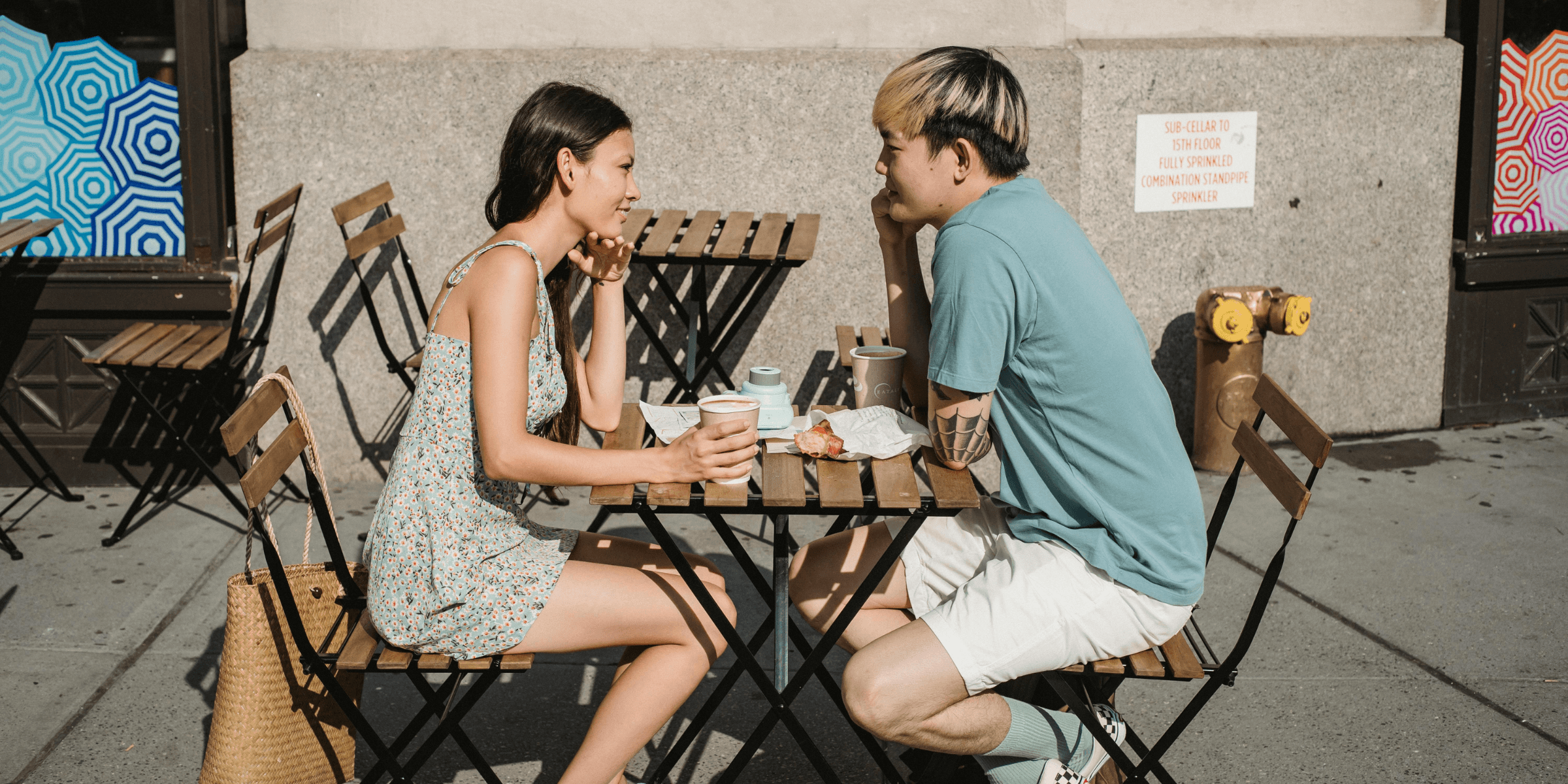 South Bay date ideas. A young Asian American couple stop for lunch at a city cafe, talking, and laughing with each other.